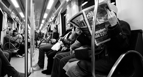 People on a train in Poland reading the newspaper
